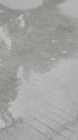 Close-up shot of raindrops splashing on the paved road