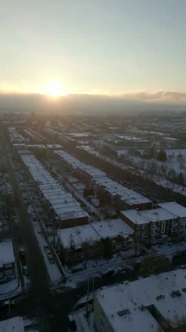 Vertical Vieux Rosemont district at winter sunset, snowcovered roofs and streets, aerial establishing