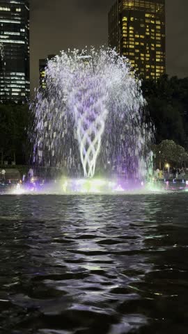 Night fountain close up with dancing water streams and vibrant RGB illumination. Hypnotic, seamless looping footage for background, urban design showcases, relaxing content, social media reels stories