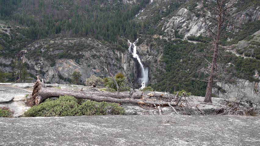 Approaching Sentinel Falls in Yosemite National Park California from cliff with fallen tree, Aerial dolly in shot 4k