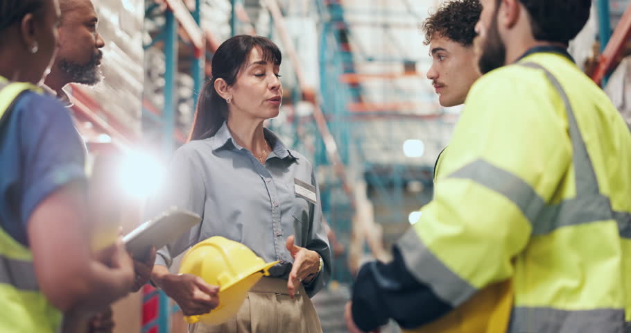 Safety inspection, tablet and logistics employees in warehouse for industrial training. Digital technology, meeting and supply chain workers with manager for helmet compliance review in factory.