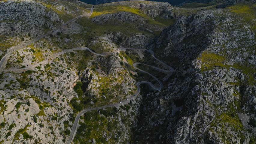 Aerial panoramic overview of Sa Calobra winding serpentine road with sharp bends and rugged cliffs