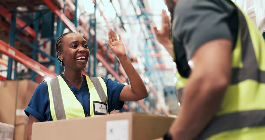 Woman, high five and team at logistics warehouse, boxes and happy with flare for celebration. People, engineer and low angle with goals, success and achievement for supply chain at distribution plant