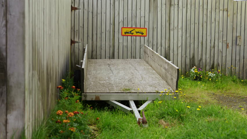 Old Trailer Parked Beside Wooden Wall