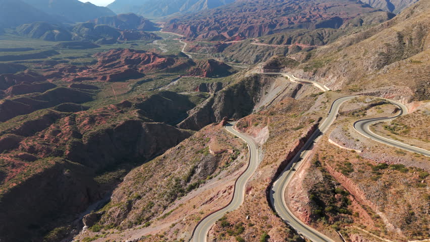 High-altitude orbital view capturing the dramatic switchbacks of the famous Ruta 40 as it climbs the steep, colorful slopes of the Cuesta de Miranda, Chilecito, La Rioja Province, Argentina
