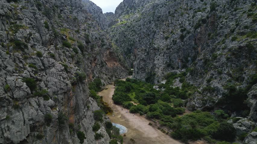 Aerial dolly of Torrent de Pareis canyon with steep rocky cliffs and winding gorge in Mallorca, establishing - Spain