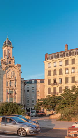 Hyperlapse of Place Antonin Jutard and the Mutuality Palace facade from the waterfront near Guillotiere Bridge in Lyon, France. Traffic flows on Quai Victor Augagneur under a blue sky timelapse