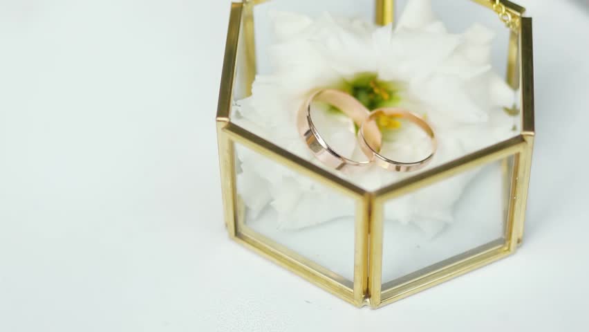 A close-up of wedding rings against a light background, symbolizing love and marriage. A bridal bouquet with lilies, floristry, and decor