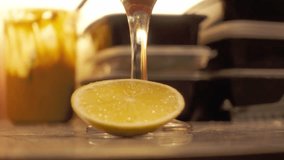 Close up of golden honey dripping over a sliced lemon on a kitchen surface. - Powered by Shutterstock - Get 15% off with code: PIKWIZARD15