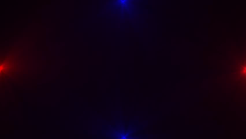Four spotlights, two red and two blue, emitting light beams on a dark background shine