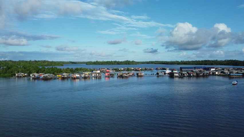 An aerial view of a fishing village in the middle of the sea with a clear blue sky in the background on Karaka Island, Papua. The fishermen