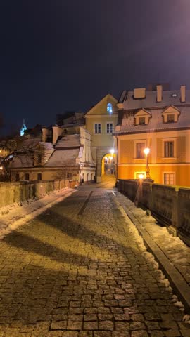 Lublin, Poland. A street lined with buildings and a bridge in the evening. Grodzka Gate, remains of the defensive walls. It also called the Jewish Gate.