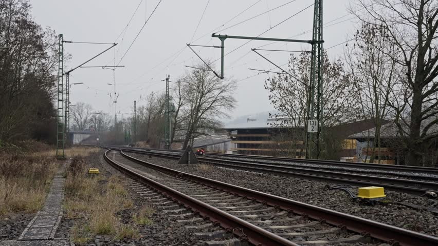 Industrial Railway With Signals, Train Tracks Amid Winter Industrial Landscape, Atmospheric Scene Of Curved Rail Tracks In Bleak Winter Industrial Environment With Signals And Distant Depot