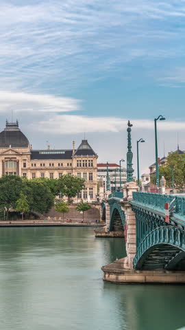 Panoramic hyperlapse view of the Rhone River and its embankment, featuring the University Jean-Moulin in Lyon, France. Includes the University Bridge and waterfront under a partly cloudy sky timelapse