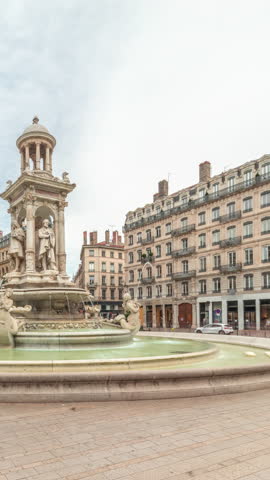 Hyperlapse of Place des Jacobins in Lyon, France, featuring the ornate Fontaine des Jacobins surrounded by historic buildings. Bustling city square under a cloudy sky timelapse