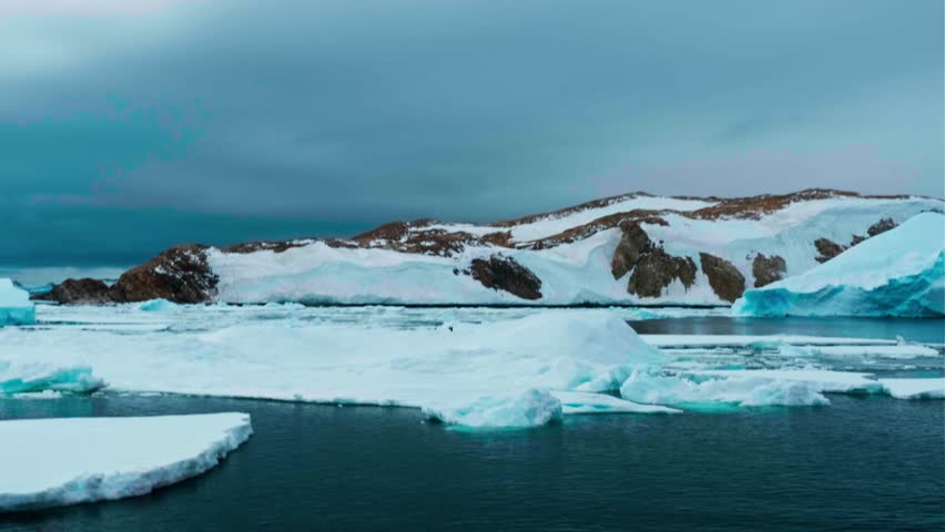 Horizontal video ship sails across Antarctic ocean. Amidst frozen beauty of Antarctica, single ship sails across ocean surrounded by ice and snow.