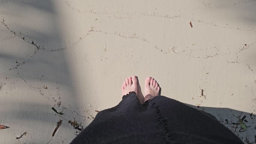 Beautiful young brunette woman in black bikini swimsuit is smiling on tropical sand of Indian sea coastline at summer sunny day, women