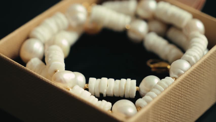 Gemstone and pearl necklace in a gift box. Handmade jewelry concept. High quality 4k footage
