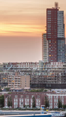 Aerial day to night transition timelapse of Katendrecht peninsula and Maashaven harbour in Rotterdam, The Netherlands. City skyline modern skyscrapers and traditional Dutch waterfront houses