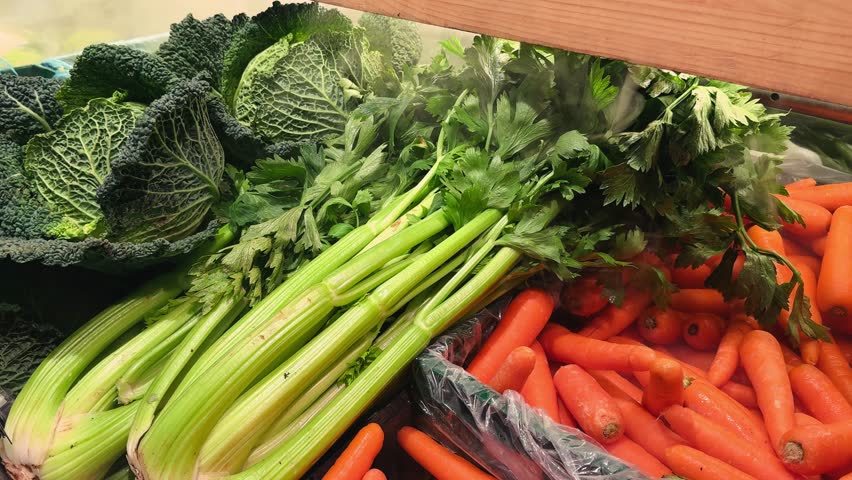 On the counter of the farm shop are fresh vegetables: Savoy cabbage, celery and carrots. High quality 4k footage