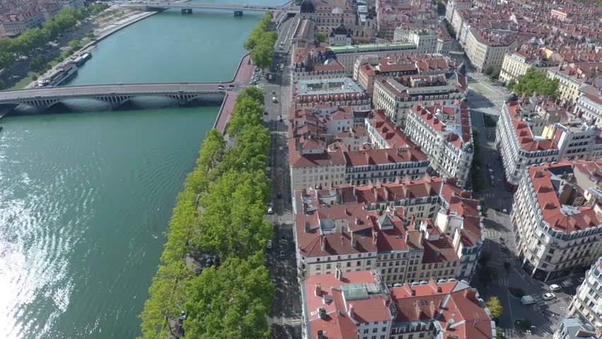 Aerial drone view over Lyon city center – River, bridge, and buildings below