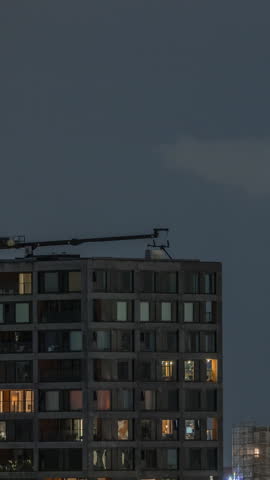 Rotterdam night cityscape timelapse with Euromast observation tower and glowing windows in high-rise buildings. Waterfront features illuminated modern skyscrapers and a scenic harbor view