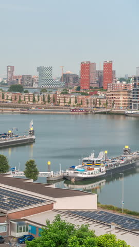 Aerial timelapse morning panoramic view over Maashaven with moored inland ships, Katendrecht and Maas River in the background. Traffic moves along nearby roads. Rotterdam, Netherlands