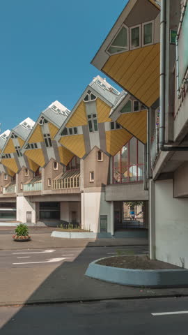 Hyperlapse of Cube House (Kubuswoningen) in Rotterdam. Unique yellow cube-shaped houses showcasing innovative architecture amid cityscape aerial timelapse. Cloudy sky and urban vibrancy. Netherlands