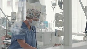 Female doctor in medical mask and butterfly print cap using stethoscope, healthcare professional working with equipment in bright clinic ward room - Powered by Shutterstock - Get 15% off with code: PIKWIZARD15