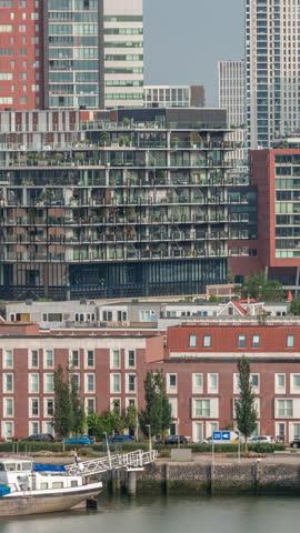 Aerial timelapse of modern buildings in Rotterdam city center, The Netherlands. Towers and skyscrapers in the financial district with warm morning light creating a vibrant skyline. Ships on waterfront
