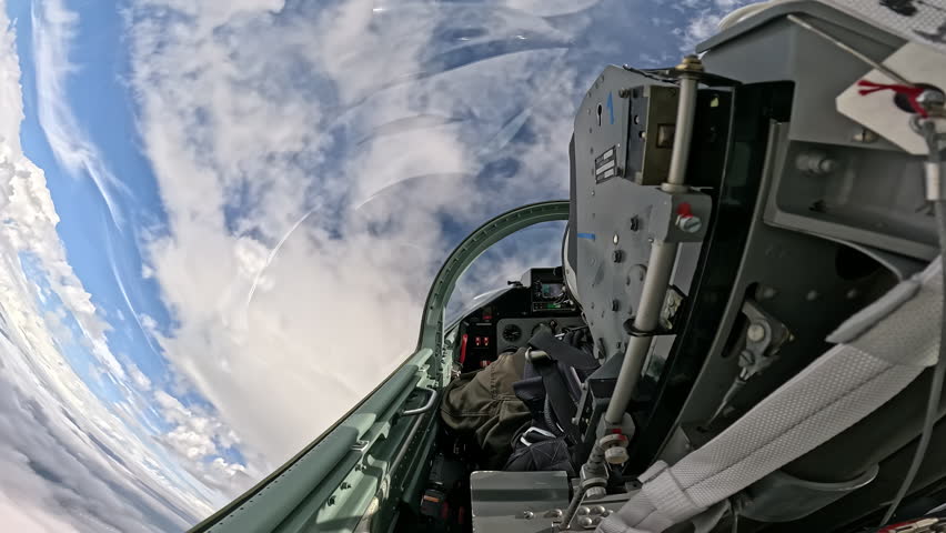 Interior view of fighter jet cockpit flying high above thick clouds, military aircraft equipment and pilot seat during mission in sky