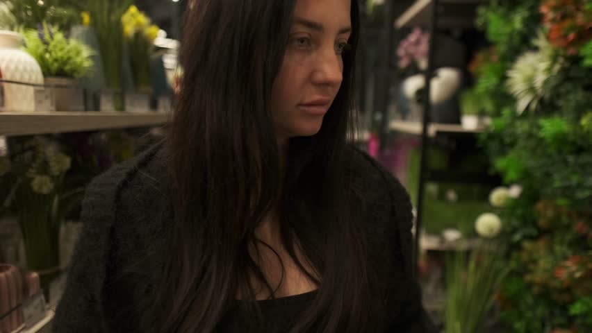 Woman choosing home decor elements in large showroom, lifestyle retail scene