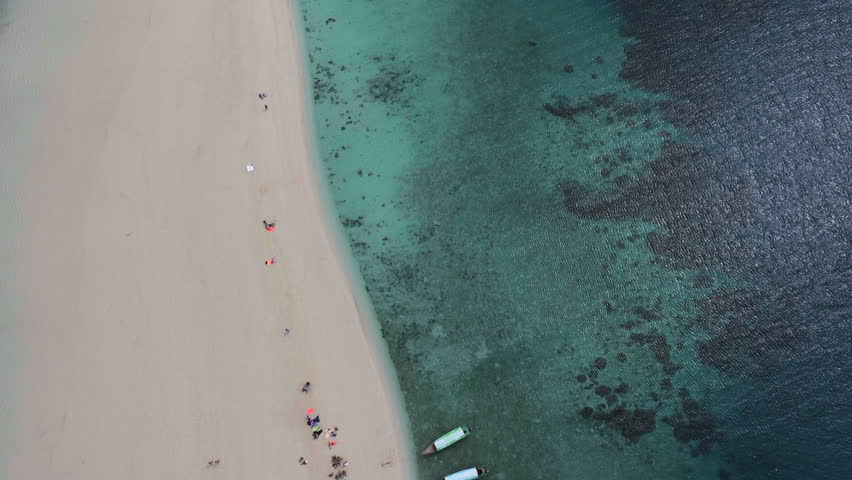 Aerial view of Nakupenda island, sandbank in ocean, white sand, boats, blue sea during low tide at sunny summer day in Zanzibar. Top view of sand spit and clear water.