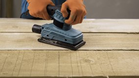 Carpenter in overalls sanding wooden boards using electric sander machine in workshop - Powered by Shutterstock - Get 15% off with code: PIKWIZARD15