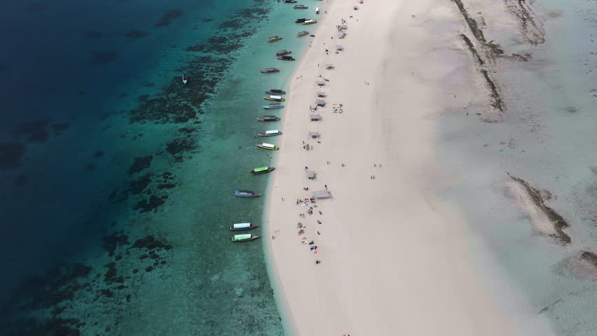 Aerial view of Nakupenda island, sandbank in ocean, white sand, boats, yachts, blue sea during low tide at sunny summer day in Zanzibar. Top view of sand spit and clear water.