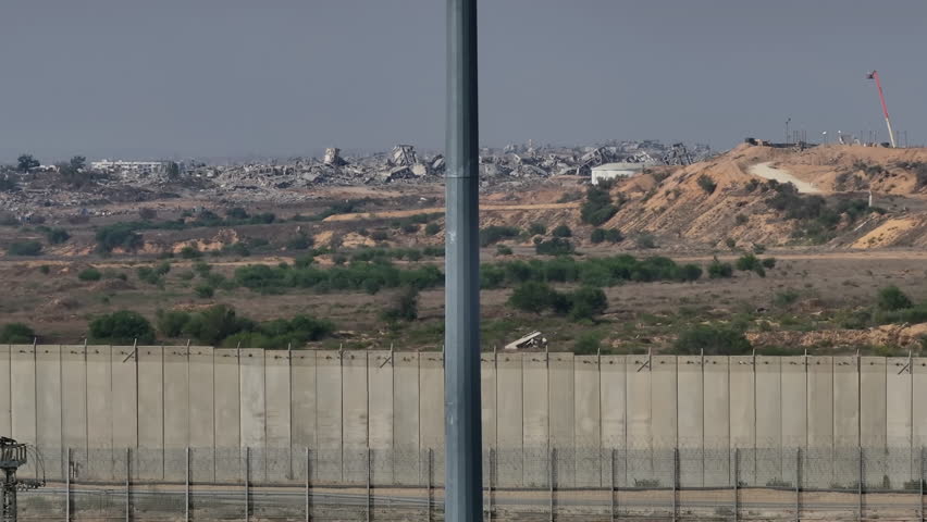 Aerial Israel Gaza Border With Flag
Drone footage starting at the Israel Gaza border fence, rising to reveal an Israeli flag and extensive destruction inside Gaza during 2023

