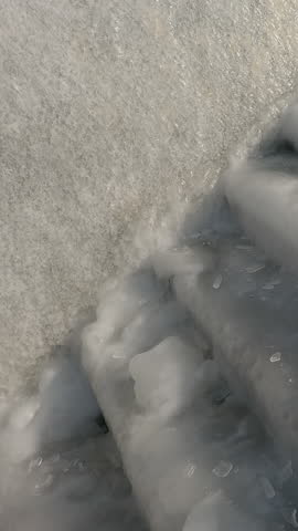 Vertical footage, Camera moves up along slippery steps covered with ice-crusted, Staircase covered with a layer of ice, Close-up