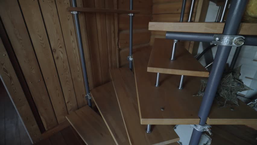 Steep spiral wooden staircase in a wooden house. Moving Up