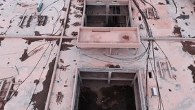 Drone overhead of an unfinished concrete building site: central tower with circular openings, scattered debris, dry terrain, daytime, no people—ideal for urban decay or construction themes. - Powered by Shutterstock - Get 15% off with code: PIKWIZARD15
