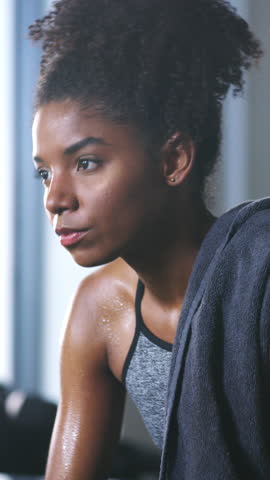 Fitness, face of woman and happy in gym for intense workout, exercise recovery and break. Athlete, african person and sweating with smile at sports club for training challenge, rest and development