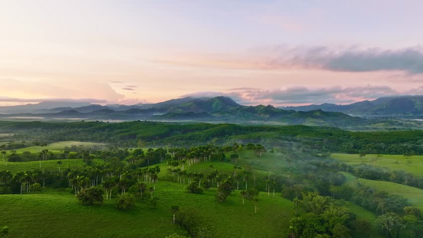 Mountain range landscape at dawn. Sunrise over the mountains, mountain peaks in the morning mist, panoramic view. Colorful rendering of a pink cloudy sky.