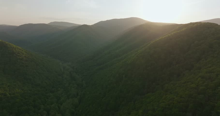 Sunset over lush green mountains in West Virginia, tranquil nature scene