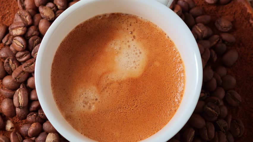Espresso in a coffee cup, background of coffee beans.	
