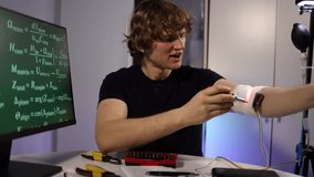 Young engineer calibrates glowing arm implant while coding neural algorithms in futuristic home lab with digital equations tools and intense focused innovation deep drive - Powered by Shutterstock - Get 15% off with code: PIKWIZARD15