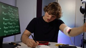 Young engineer calibrates glowing arm implant while coding neural algorithms in home lab with digital equations tools and intense focused determination driven research session - Powered by Shutterstock - Get 15% off with code: PIKWIZARD15
