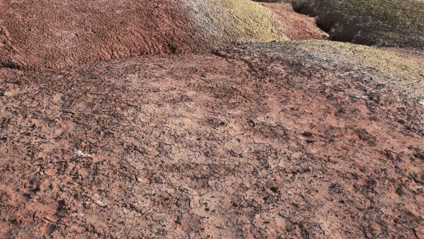 Zhangye Danxia Geopark, Zhangye, Gansu Province, China - Layered, Multicolored Hills rise in Rolling Waves, Showcasing Striking Bands of Red, Yellow, and Gray Rock Under a Clear Sky - Tilt Shot