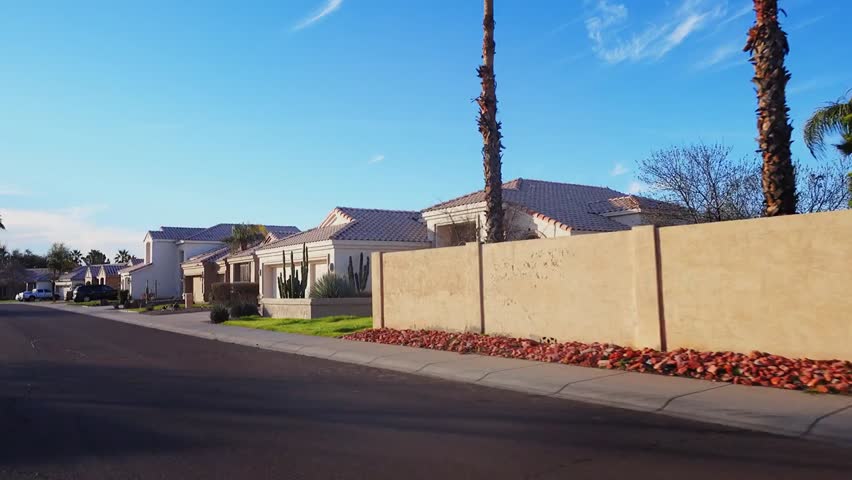Three-quarter view driving through a typical suburban neighborhood in Phoenix, Arizona, showcasing residential streets, houses, and everyday suburban life.