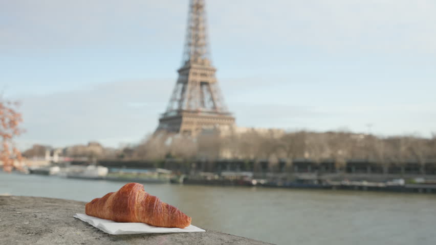 Paris France Handheld Shot of Croissant with Blurred Eiffel Tower