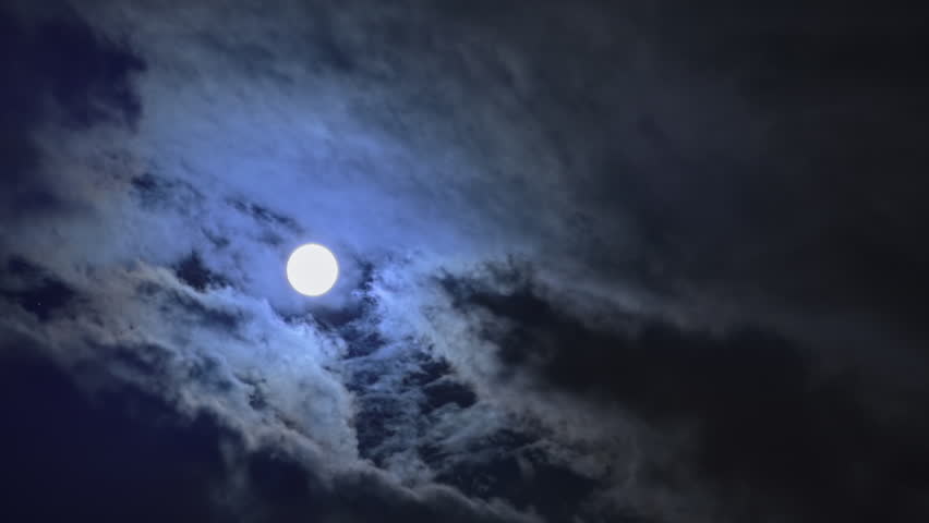 Full moon in Moonlight night behind clouds time lapse