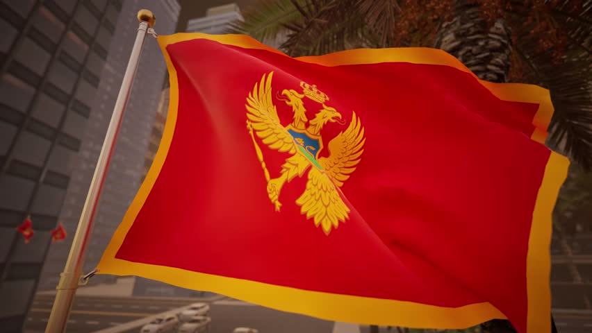 The Montenegro national flag waves gently at sunset along a modern city street, illuminated by warm golden light that reflects across surrounding buildings and urban surfaces. The contrast between the rich red of the flag and the warm tones of the sky creates a calm and visually balanced atmosphere. The golden emblem remains clearly visible, reinforcing the flag’s symbolic presence.

Urban elements such as streets, buildings, and light traffic are present without overpowering the composition, keeping the flag as the central focus. The absence of recognizable landmarks allows the image to function as a general representation of Montenegro rather than a specific location. Subtle motion in the flag adds realism while preserving a composed and professional tone.

This visual is suitable for editorial use related to international news, cultural storytelling, European affairs, or travel features. Its warm lighting and neutral composition provide flexibility for a wide range of informational and media applications.
